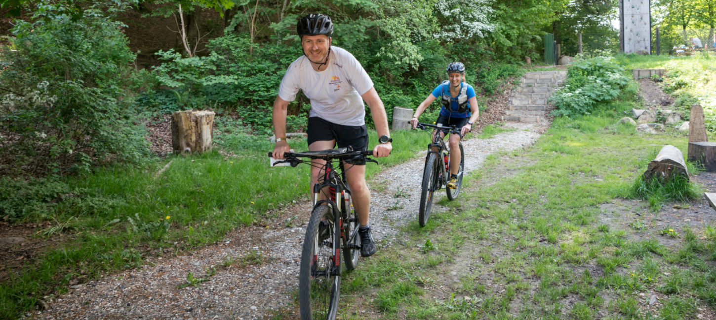 to personer der cykler i skoven